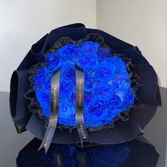 Bouquet of blue roses in a black wrap with a visible brand name on a white background